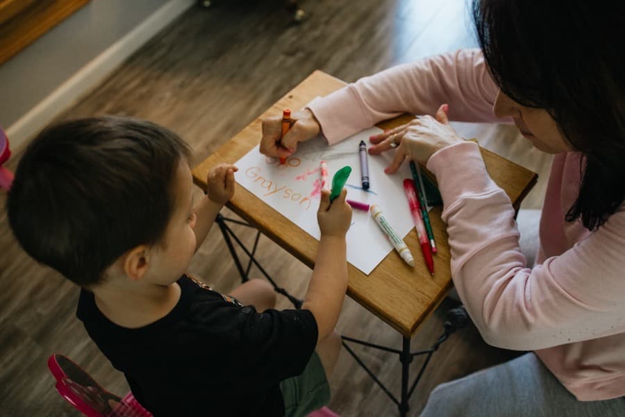 A teacher guiding a child's schoolwork at home