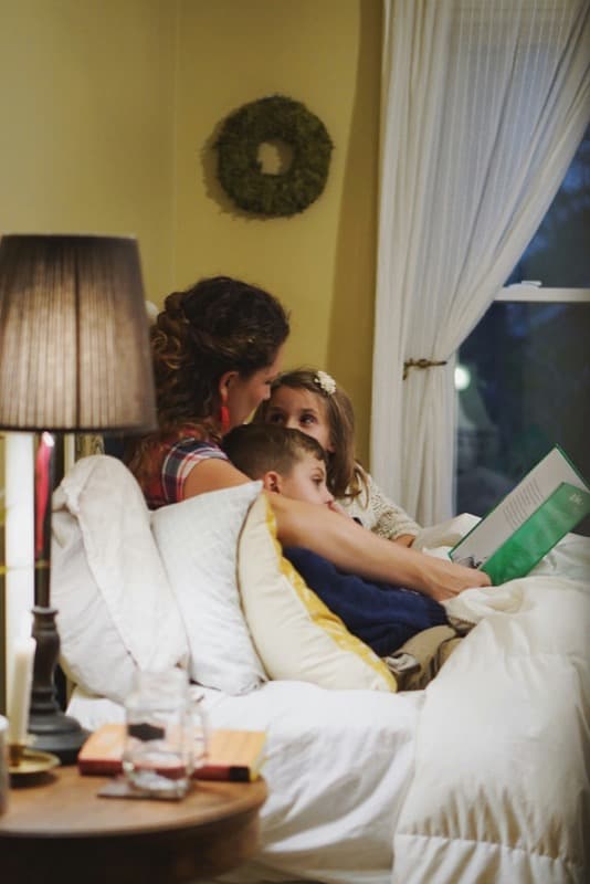 A parent reading with two children